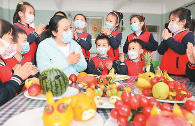5月11日，在山东省东营市文汇街道中心幼儿园，老师在指导学生学习各种水果的营养价值，引导学生树立健康饮食新风尚。 　　刘智峰摄（人民视觉）